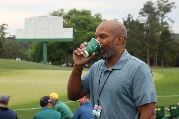 AJC Senior Sports Editor Rod Beard enjoys a cup of Masters Blend fresh brewed coffee on the 18th green during a practice round of the Masters golf tournament on Monday, April 6, 2026, in Augusta. (Jason Getz/AJC) 