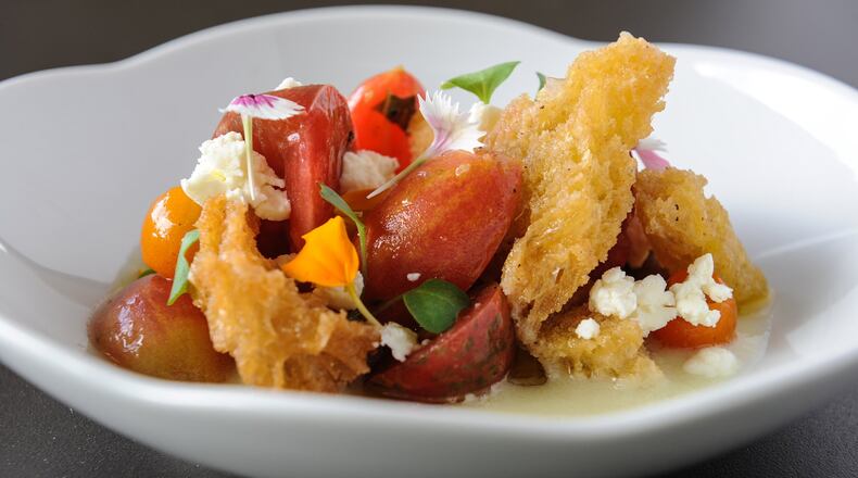 An heirloom tomato salad features cherry tomatoes, with chunks of fromage blanc, basil and croutons atop a thin coating of a cucumber gazpacho. (BECKY STEIN PHOTOGRAPHY)
