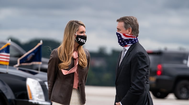 FILE - Sens. Kelly Loeffler (R-Ga.) and David Perdue (R-Ga.) wait to greet President Donald Trump as he exits Air Force One in Atlanta, Sept. 25, 2020. Trump and Democratic presidential nominee Joe Biden remain locked in a tight race in Georgia, and the state’s two Senate seats, which are both up for grabs, are competitive, according to a poll of state voters released Friday. (Anna Moneymaker/The New York Times)