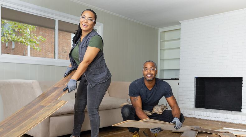 As seen on HGTV's Married to Real Estate, hosts Mike Jackson and Egypt Sherrod (L) remove the old flooring during demo in the Cole's living room. (Working)