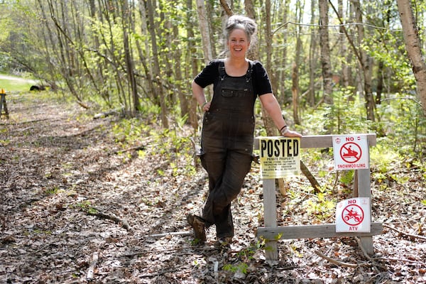 Heather Donahue, the star of the 1999 low-budget hit movie The Blair Witch Project, poses next to a "posted" sign in on a rural road, Tuesday, May 13, 2025, in Freedom, Maine. (AP Photo/Robert F. Bukaty)
