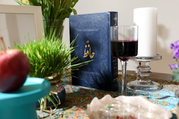 A book by Persian poet Hafez sits on the ceremonial table at the Persian Cultural Center of Atlanta. The tables are typically adorned with seven symbolic items, each beginning with a letter in Farsi similar to ‘S.’(Arvin Temkar/AJC)