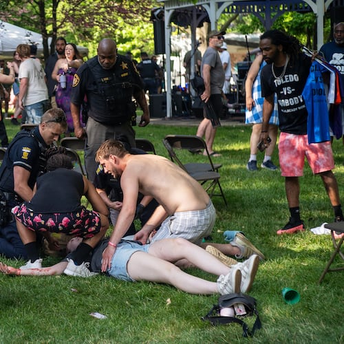 Police treat a person after multiple people were shot at a community festival Saturday, June 6, 2026, in Toledo, Ohio. (Rich Berry via AP)