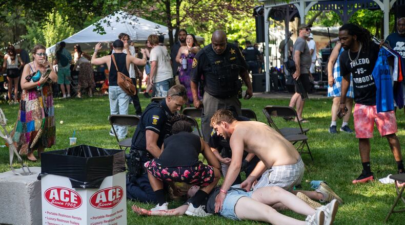 Police treat a person after multiple people were shot at a community festival Saturday, June 6, 2026, in Toledo, Ohio. (Rich Berry via AP)
