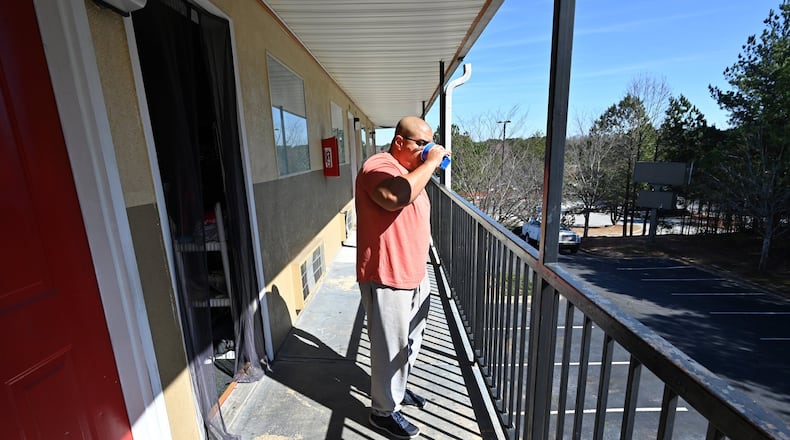 Tony Fernandez holding his water cup gets fresh air outside their extended stay hotel room in Norcross on Saturday, February 15, 2020. No one knows for sure how many, but thousands of families around metro Atlanta live in extended stay hotels. They are typically working poor, people who make enough money to sort of get by day-to-day, but they don’t make enough to get themselves a stable apartment and certainly not to buy a home. (Hyosub Shin / Hyosub.Shin@ajc.com)
