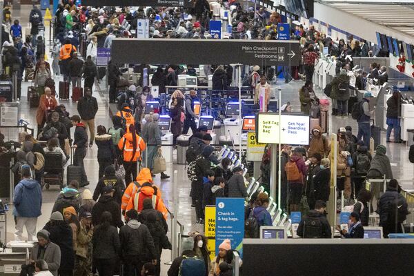Early morning travelers check in before their flights at Hartsfield-Jackson International Airport Saturday, Dec. 24, 2022. (Photo: Steve Schaefer / steve.schaefer@ajc.com)