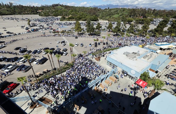 Fans line up to enter Dodger Stadium to receive a bobblehead doll of Los Angeles Dodgers' Shohei Ohtani before a baseball game against the Atlanta Braves, Wednesday, April 2, 2025, in Los Angeles. (AP Photo/Kevork Djansezian)