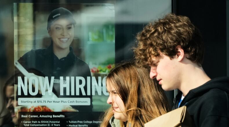 A hiring sign is displayed at a restaurant, in Niles, Ill., Tuesday, April 7, 2026. (AP Photo/Nam Y. Huh)