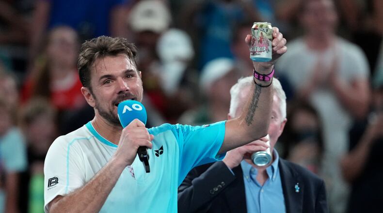 Stan Wawrinka of Switzerland holds up a beer following his third round loss to Taylor Fritz of the U.S. at the Australian Open tennis championship in Melbourne, Australia, Saturday, Jan. 24, 2026. (AP Photo/Asanka Brendon Ratnayake)