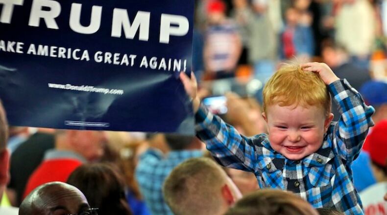 A young supporter of Republican presidential candidate Donald Trump waves a sign as he waits for the candidate during a rally in Charleston, W.Va., Thursday, May 5, 2016. (AP Photo/Steve Helber)