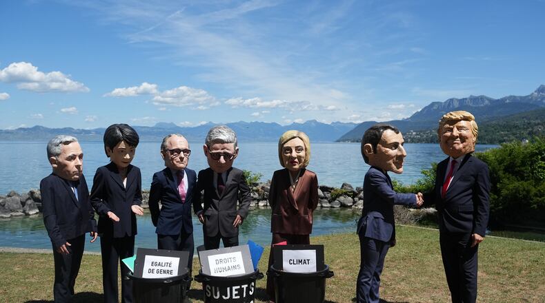 Oxfam's satirical 'big heads' of the G7 leaders pose, in Evian-les-Bains, France, Sunday, June 14, 2026, ahead of the G7 summit scheduled to take place in France June 15-17. (AP Photo/Thibault Camus)