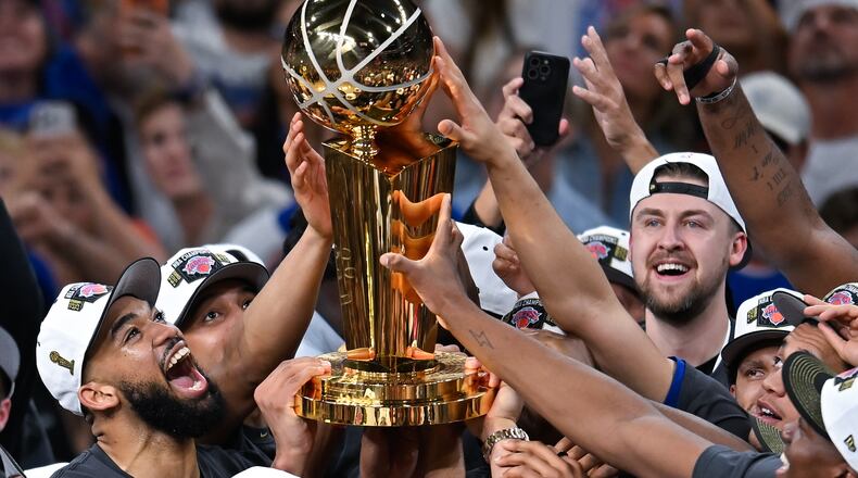 The New York Knicks celebrate with the Larry O'Brien Championship Trophy after defeating the San Antonio Spurs in Game 5 of the NBA Finals basketball series, Saturday, June 13, 2026, in San Antonio. (AP Photo/Darren Abate)
