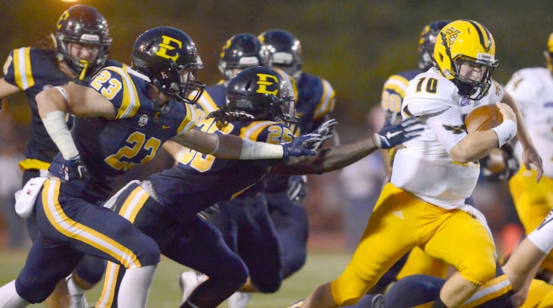 KSU STARTS OFF WINNING--Kennesaw State quarterback Trey White avoids East Tennessee State defenders Cole West (23) and Darren Ardis (25) during ETSU's first college football game since 2003, Thursday, Sept. 3, 2015, in Johnson City, Tenn. (David Crigger/Bristol Herald Courier via AP)