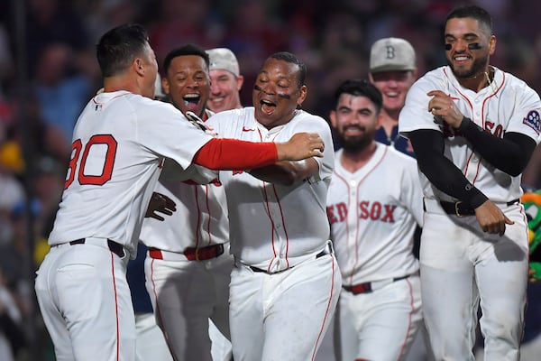 Boston Red Sox's Rafael Devers, center, celebrates with teammates as he scores after hitting a walkoff home run in the ninth inning of a baseball game against the Atlanta Braves, Saturday, May 17, 2025, in Boston. (AP Photo/Steven Senne)