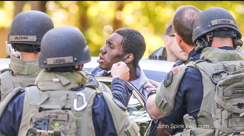 Marietta police load an attempted robbery suspect into a vehicle after he allegedly ran inside a Springhollow Lane home, causing a standoff on Wednesday, Oct. 25, 2017.