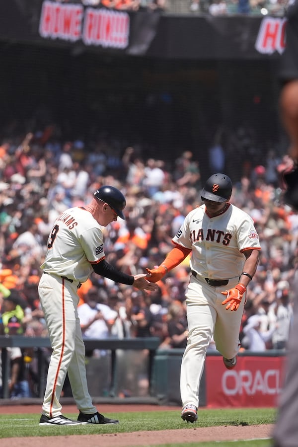 San Francisco Giants' Rafael Devers, right, is congratulated by third base coach Matt Williams after hitting a two-run home run during the third inning of a baseball game against the Boston Red Sox in San Francisco, Saturday, June 21, 2025. (AP Photo/Jeff Chiu)
