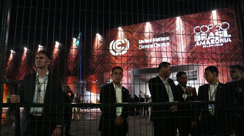 Security personnel stand behind a fence outside the venue for the COP30 U.N. Climate Summit, Tuesday, Nov. 11, 2025, in Belem, Brazil. (AP Photo/Joshua A. Bickel)