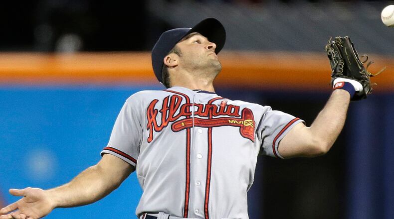 Atlanta Braves second baseman Dan Uggla (26) misplays a routine pop-up allowing New York Mets' David Wright to reach on an error in the first inning of a baseball game at Citi Field in New York, Sunday, May 26, 2013. (AP Photo/Kathy Willens)