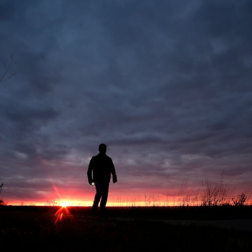 FILE - A man walks along a trail during sunset near Manhattan, Kan., on Nov. 20, 2015. (AP Photo/Charlie Riedel, File)