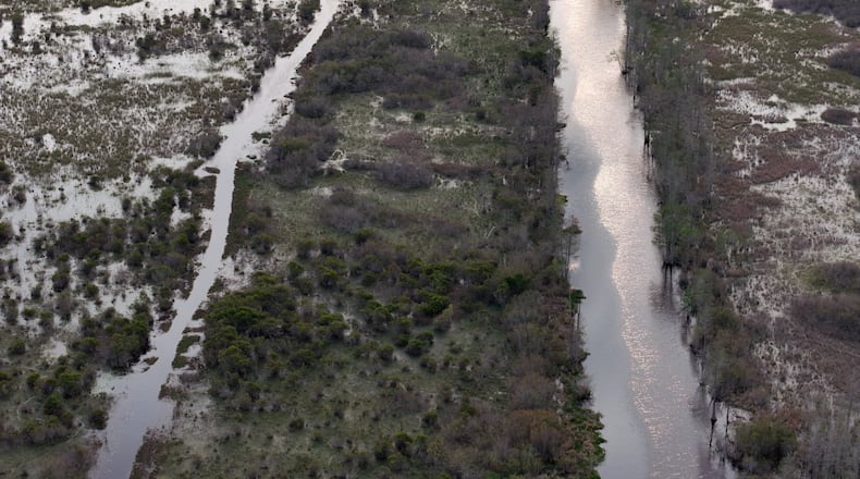 Drone photograph shows Suwannee Canal (right) and Day Use Canoe Trail (left) in the Okefenokee Swamp, Monday, Mar. 18, 2024, in Folkston. Last month, the Georgia Environmental Protection Division (EPD) released draft permits to Twin Pines Minerals for a 584-acre mine that would extract titanium and other minerals from atop the ancient sand dunes on the swamp’s eastern border, which holds water in the refuge. (Hyosub Shin / Hyosub.Shin@ajc.com)