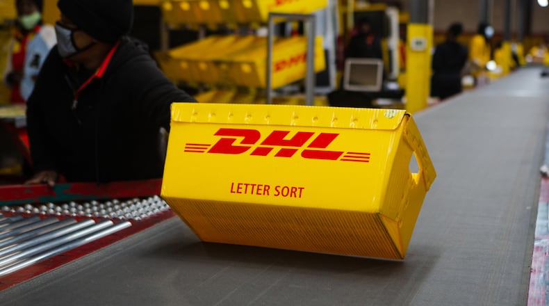 A DHL box is sent down the conveyer belt on Wednesday, December 16, 2020, at DHL Express in Atlanta. Workers at the shipping center worked to fulfill orders during the holiday rush. CHRISTINA MATACOTTA FOR THE ATLANTA JOURNAL-CONSTITUTION.