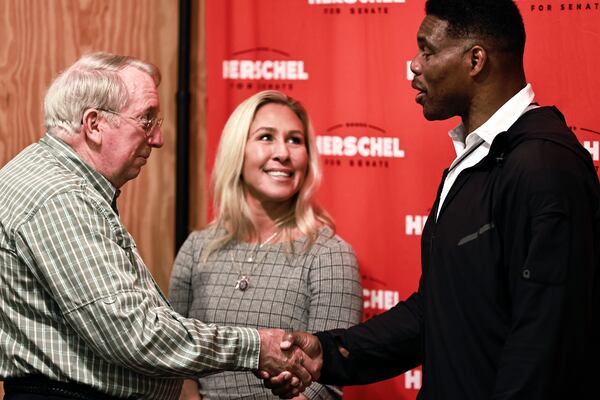 Floyd Farless (left) shakes hands with Republican U.S. Senate candidate Herschel Walker (right) as U.S. Rep. Marjorie Taylor Green (center) looks on in Rome, Georgia, on Oct. 24, 2022. (Natrice Miller/AJC)  