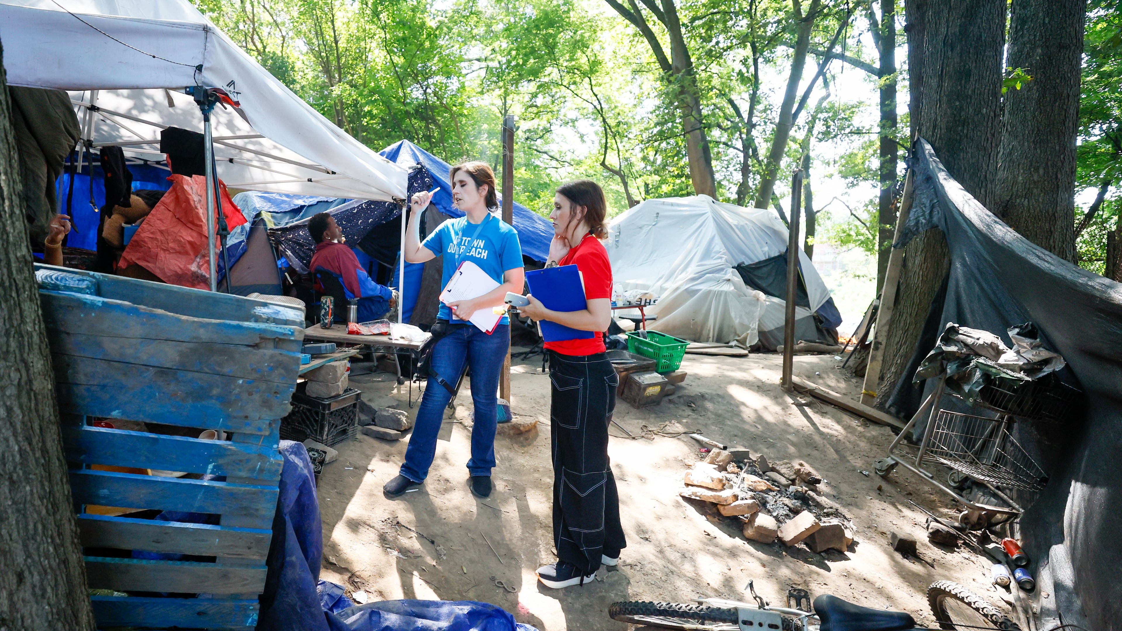 Tracy Woodard from InTown Cares (left) and Lauren Hopper from Mercy Care organization work with residents at the Copperton Street encampment in August 2024.
(Miguel Martinez / AJC)