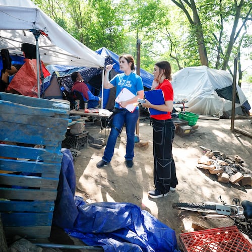 Tracy Woodard from InTown Cares (left) and Lauren Hopper from Mercy Care organization work with residents at the Copperton Street encampment in August 2024.
(Miguel Martinez / AJC)