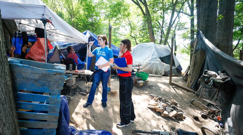 Tracy Woodard from InTown Cares (left) and Lauren Hopper from Mercy Care organization work with residents at the Copperton Street encampment in August 2024.
(Miguel Martinez / AJC)