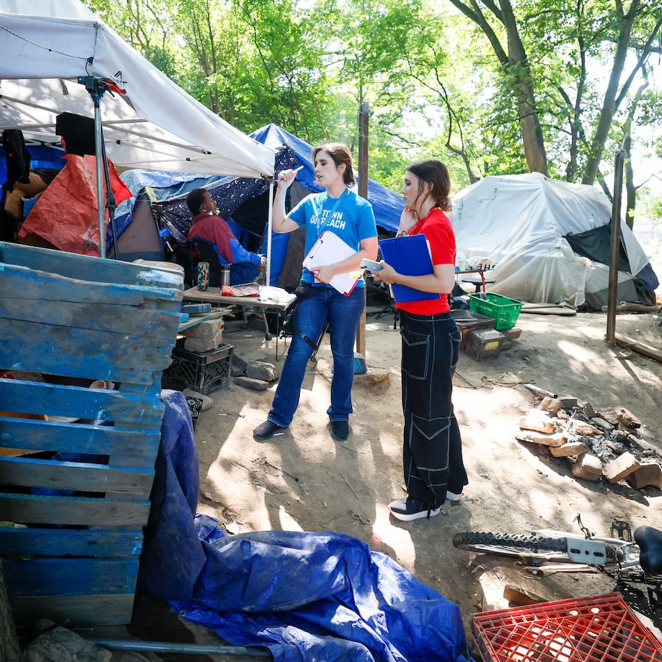 Tracy Woodard from InTown Cares (left) and Lauren Hopper from Mercy Care organization work with residents at the Copperton Street encampment in August 2024.
(Miguel Martinez / AJC)