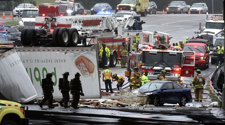Emergency workers investigate where two tractor-trailers plunged off I-285 onto Ga. 400 on Friday, September 18, 2015. HYOSUB SHIN / HSHIN@AJC.COM