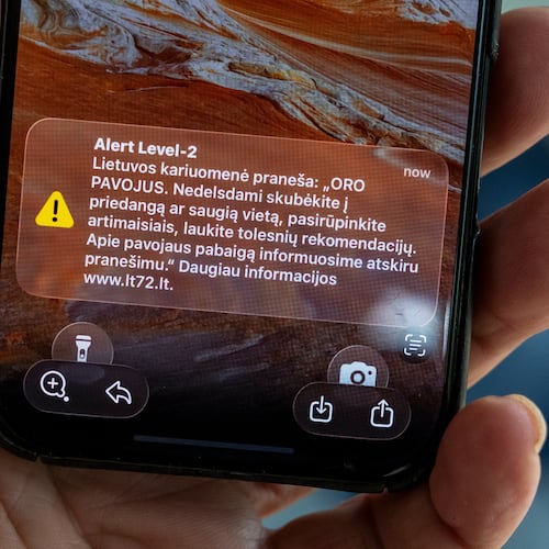 The phone shows the received message "The Lithuanian military reports: "AIR DANGER. Hurry to cover or a safe place without delay, take care of your loved ones, wait for further recommendations. We will inform you about the end of the danger in a separate message", in Vilnius, Lithuania, Wednesday, May 20, 2026. (AP Photo/Mindaugas Kulbis)