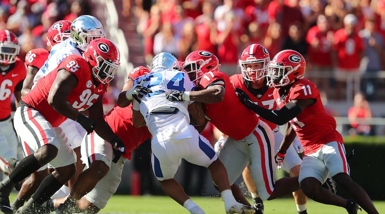 Georgia defenders smother Kentucky running back Chris Rodriguez to bring up third-and-16 on Saturday at Sanford Stadium. “Curtis Compton / Curtis.Compton@ajc.com”