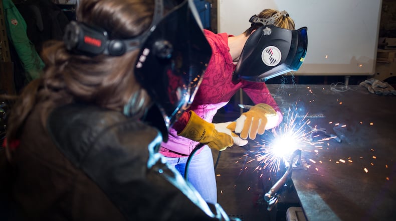 Bria Sativa Aguayo, left, founder of the Atlanta-based Becoming a Welder Inc., teaches a recent local workshop on careers in welding. She is trying to draw more women into the industry.