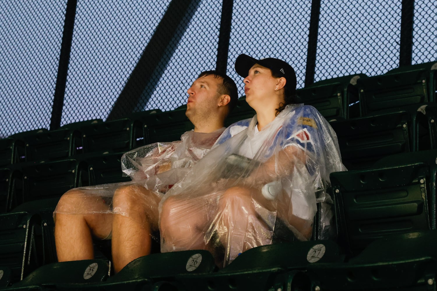 Fans react to the lightning during a rain delay before the first inning of the Braves versus Philadelphia Phillies game at Truist Park in Atlanta on Friday, June 27, 2025. (Abbey Cutrer / AJC)