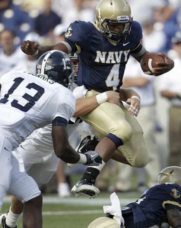 Navy quarterback Ricky Dobbs (4) gets tackled from behind by a Georgia Southern defender as Georgia Southern linebacker Darius Eubanks (13) comes in on the play.