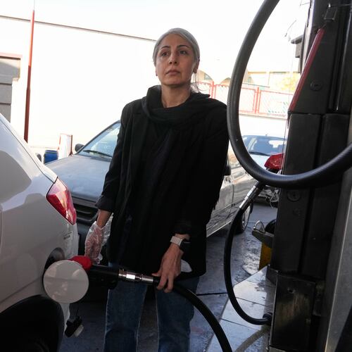 A woman fills her car at a gas station in Tehran, Iran, Thursday, Nov. 27, 2025. (AP Photo/Vahid Salemi)