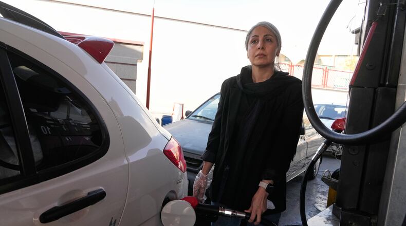 A woman fills her car at a gas station in Tehran, Iran, Thursday, Nov. 27, 2025. (AP Photo/Vahid Salemi)