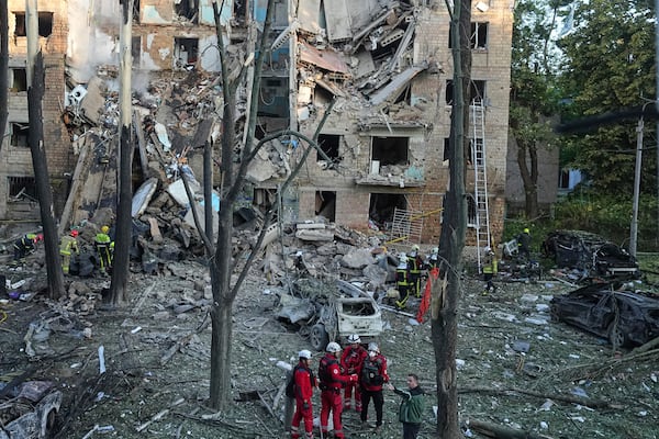 Firefighters work in a destroyed apartment building after a Russian attack in Kyiv, Ukraine, early Monday, June 23, 2025. (AP Photo/Efrem Lukatsky)