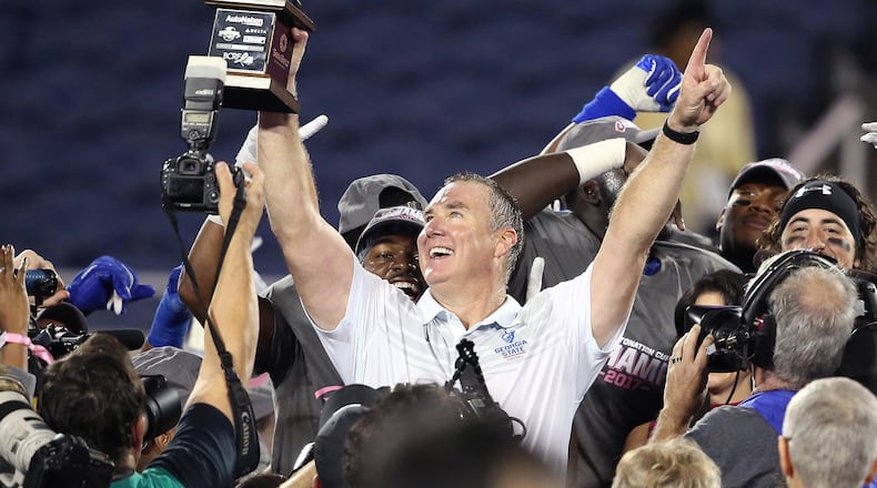 Georgia State head coach Sean Elliott hoists the championship trophy after winning the Cure Bowl, 27-17, against Western Kentucky at Camping World Stadium in Orlando, Fla., on Saturday, Dec. 16, 2017. (Stephen M. Dowell/Orlando Sentinel/TNS)