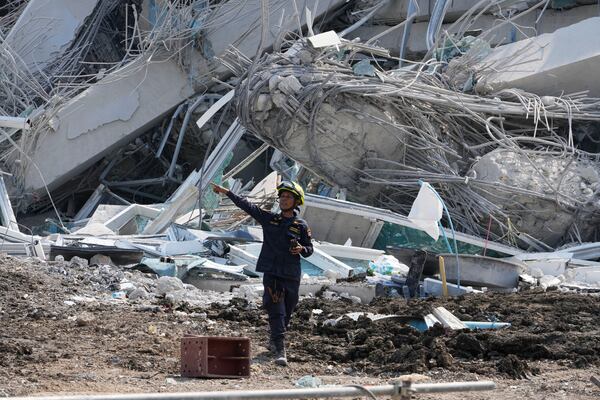 A rescuer gives instruction at the site of an under-construction high-rise building that collapsed on Friday after an earthquake in Bangkok, Thailand, Saturday, March 29, 2025. (AP Photo/Manish Swarup)