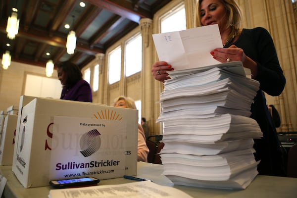 Valerie Hoff of 11Alive slowly chips away at a stack of documents that are part of the 1.4 million released in the Atlanta City Hall bribery case on Thursday, Feb. 9, 2017. (Henry Taylor/AJC)