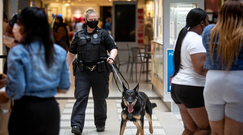 K9 Handler Stephanie Bong walks through the Perimeter Mall with her German Shepherd trained in weapons detection Friday, March 9, 2021. STEVE SCHAEFER FOR THE ATLANTA JOURNAL-CONSTITUTION