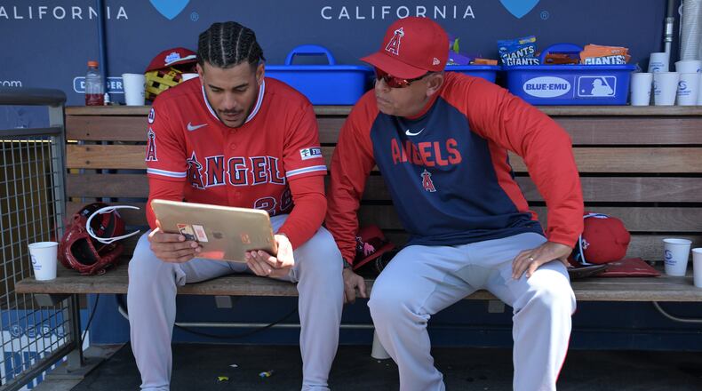 FILE - Los Angeles Angels' Jose Siri, left, looks at an iPad in the dugout with Angels' assistant hitting coach Jobel Jiménez during a baseball game against the Los Angeles Dodgers, June 7, 2026, in Los Angeles. (AP Photo/Jayne Kamin-Oncea, File)