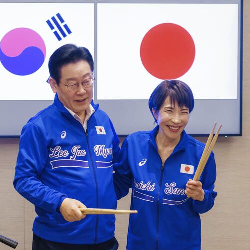 In this photo released on the official website of Prime Minister's Office of Japan, Japanese Prime Minister Sanae Takaichi, right, and South Korean President Lee Jae Myung react as they play drump together after their talks in Nara, western Japan Tuesday, Jan. 13, 2026. (Prime Minister's Office of Japan via AP)