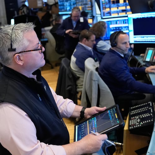 People work on the floor at the New York Stock Exchange in New York, Monday, April 13, 2026. (AP Photo/Seth Wenig)