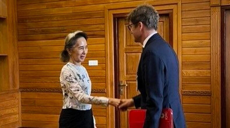 In this photo released by Myanmar President Office on Monday, Aug. 3, 2026, Myanmar's ousted leader Aung San Suu Kyi, left, shakes hands with Arnaud de Baecque, resident representative of the International Committee of the Red Cross, during their meeting in Naypyitaw, Myanmar. (Myanmar President Office via AP)