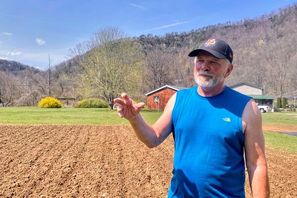 Retired coal miner Stanley "Goose" Stewart stands outside his home in Orgas, W.Va., on Wednesday, April 2, 2025. (AP Photo/John Raby)