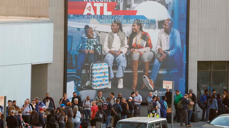 Travelers line up all the way to the end and circle back on the sidewalks for security checks early Monday morning on March 23, 2026, at Hartsfield-Jackson Atlanta International Airport. (Miguel Martinez/AJC)