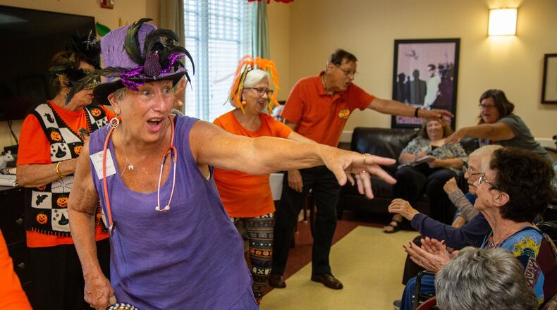 The Sing-Alongs member Mary Kay Kreisle (foreground) helps lead residents in songs at AG Rhodes at Wesley Woods in Decatur. For nearly nine years, the group calling itself the Sing-Alongs has been singing to patients in facilities in DeKalb and Fulton counties. Photo by Phil Skinner